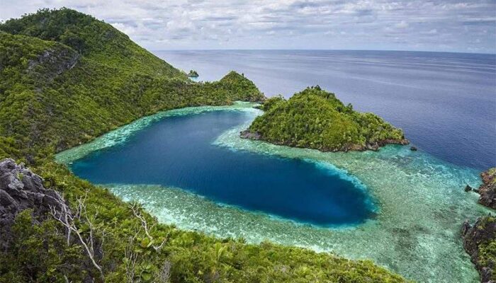 a blue water and green hills